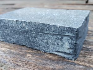 activated charcoal goat milk soap bar on a wood table