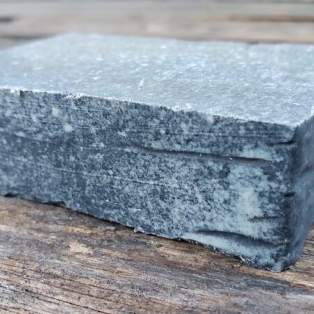 activated charcoal goat milk soap bar on a wood table